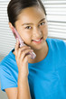 Photo: Asian preteen girl talking on cell phone and looking at viewer. Asian preteen girl talking on cell phone and looking at viewer.