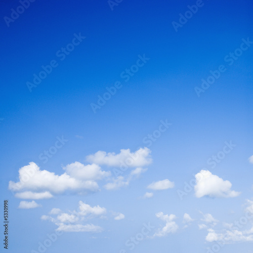 Blue sky with some white puffy clouds.