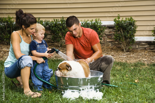 Photo: Family giving dog a bath. Family giving dog a bath.