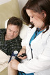 home health nurse taking patient's blood pressure.  
