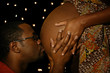 husband kissing his wife's pregnant belly