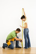 Couple measuring wall.