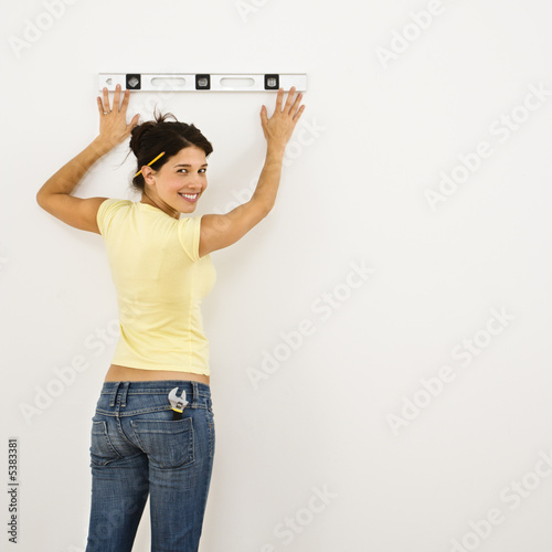Photo: Woman leveling wall. Woman leveling wall.