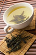 Green tea in a white cup with a tea leafs Green tea in a white cup with a tea leafs