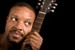 african american blues player with guitar, looking into copy 