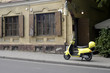 Yellow motor scooter left in front of the cafe entrance