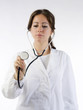 cute brunette in white medical gown focus on the stethoscope