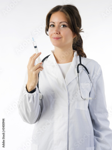 Foto: cute brunette in medical gown in acting to make a puncture cute brunette in medical gown in acting to make a puncture