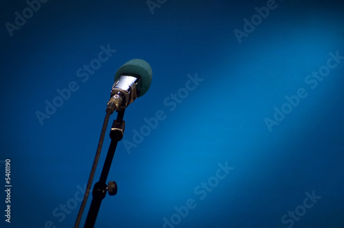 Photo: Microphone on the stage with the blue background and lights Microphone on the stage with the blue background and lights