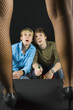Two men sitting in front of woman's legs in dark room Two men sitting in front of woman's legs in dark room