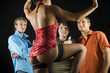 Three men standing in front of dancing woman in dark room