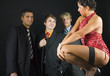 Three businessmen standing in front of woman in dark room Three businessmen standing in front of woman in dark room