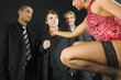 Three businessmen standing in front of woman in dark room