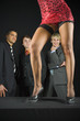 Three businessmen standing in front of woman in dark room