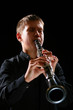 The teenager playing on a clarinet. 