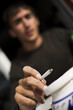 jeune fumeur et cigarette en main en gros plan lieu public