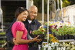 Happy smiling couple picking out flowers at planet market.