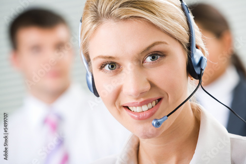 Photo: Face of young charming confident woman with headset Face of young charming confident woman with headset