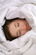 Photo: A young woman sleeping under a blanket A young woman sleeping under a blanket