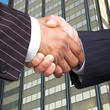 Businessmen in pinstripe suits shake hands. Businessmen in pinstripe suits shake hands.