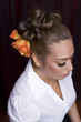 Female model with styled hair on red background.
