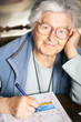 Senior woman solving crossword puzzle, portrait Senior woman solving crossword puzzle, portrait
