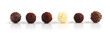 Row of assorted chocolate truffles on white background