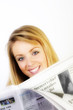 Girl smiling, reading the paper