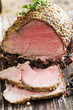 sliced rare beef, roast covered in pepper and herbs