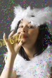 a beautiful young girl in white carnival mask blowing a ribbon