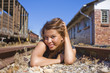 Girl in black and white dress on train tracks