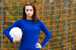 A beautiful soccer player carrying a soccer ball