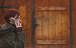 Panning image of a redheaded girl using a mobile phone 