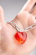 Heart on a chain wound on a palm