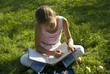 The girl draws on a meadow