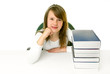 Portrait of Happy young schoolgirl smiling from behind book 