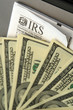 Photo: Stack of hundred dollar bills laid out on top of IRS form, Stack of hundred dollar bills laid out on top of IRS form,