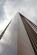 A commercial building pointing towards the grim sky.