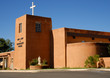 Brightly lit sculpture near adobe church in Taos, New Mexico