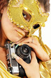 Sexy smiling girl in golden mask with old photo camera. Sexy smiling girl in golden mask with old photo camera.