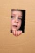 Images : young girl looking from brown carton box