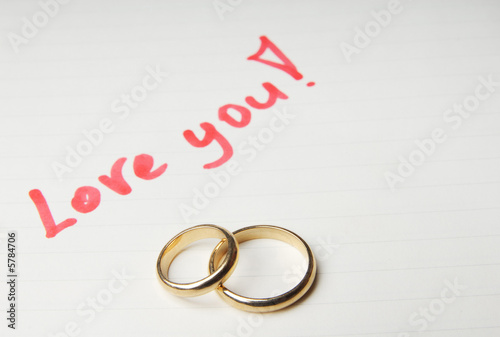 Photo: Loving letter with golden wedding rings Loving letter with golden wedding rings