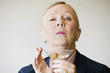 Dramatic senior woman in a man's suit holding a Martini.