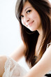 A cute young Asian teenager in white dress on white background