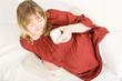 A pregnant lady holding a glass of milk and smiling