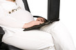 A pregnant lady typing on her laptop