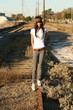 Young woman walkgin on railroad tracks