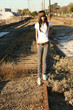 Young woman walkgin on railroad tracks