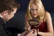 Blond woman inspecting diamond size with magnifying glass Blond woman inspecting diamond size with magnifying glass