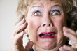 Close-up of a horrified senior woman with her mouth open.